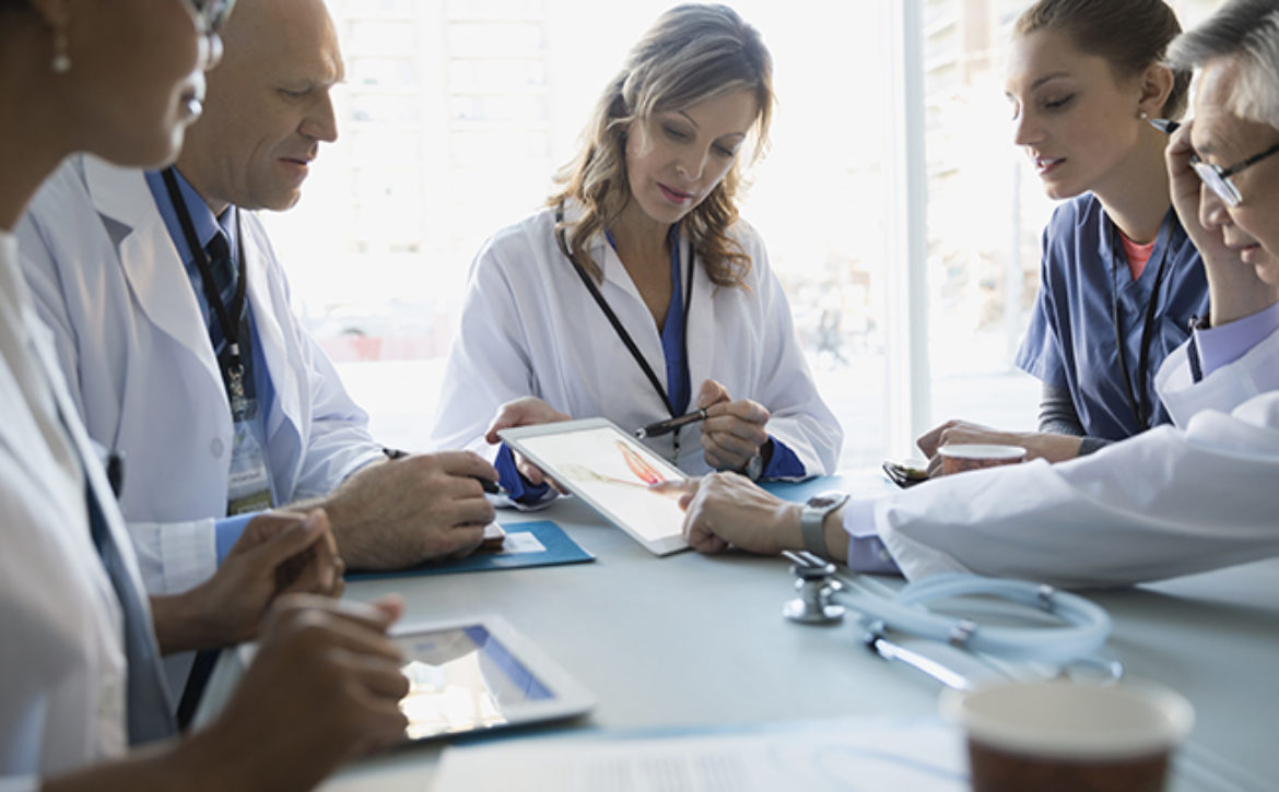 Doctors using digital tablet in meeting