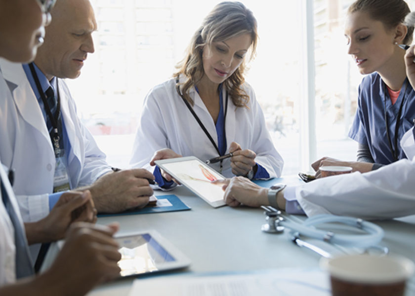 Doctors using digital tablet in meeting